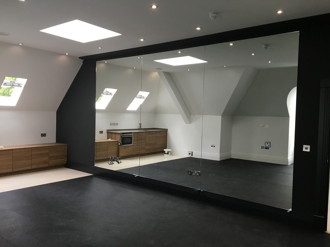 Frameless glass wall dividing loft conversion in Thame